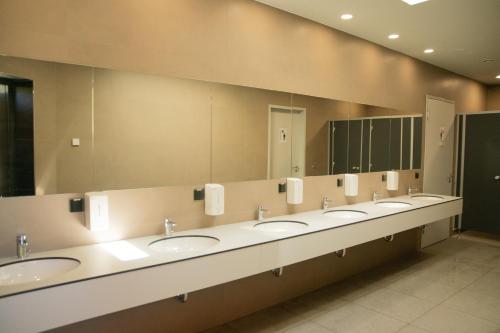 a row of sinks in a public restroom with mirrors at Munich Oktoberfest Central Camping Village in Munich
