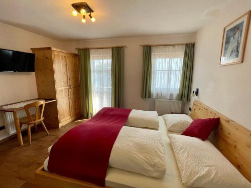 a bedroom with a large bed and a desk at Da Kathi in San Candido
