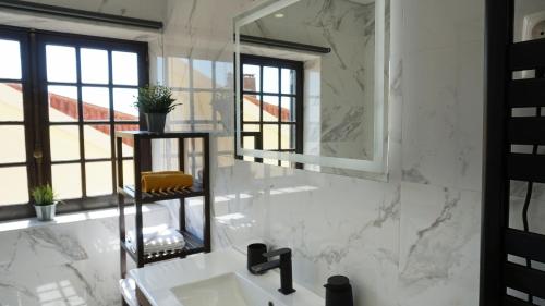 a white bathroom with a sink and a mirror at Casa Grande Holidays in São Martinho do Porto