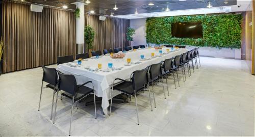 a long table in a room with chairs and a screen at Sercotel Caspe in Barcelona