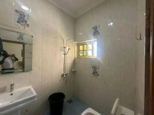 a bathroom with a sink and a toilet and a window at Appartement meublé service in Cotonou