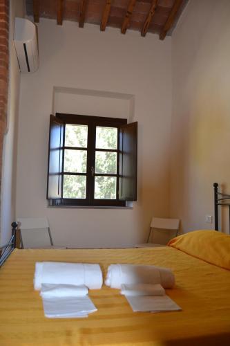 a bedroom with a large wooden bed with a window at Antico Borgo Casalappi in Campiglia Marittima