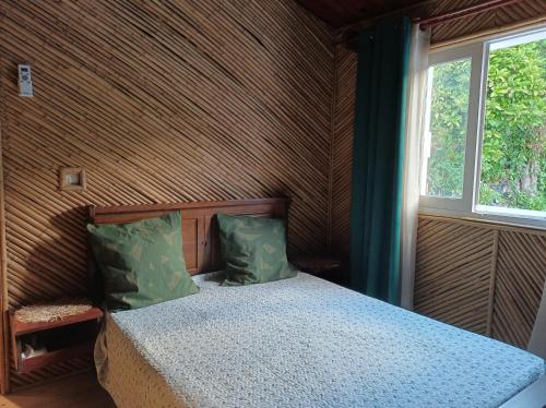 a bedroom with a bed in a room with a window at La baie rose in Sainte-Rose