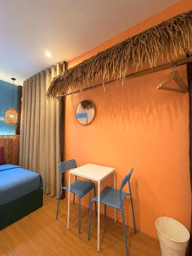 a room with a table and chairs and a bed at Casa Paco Siargao in Catagnan