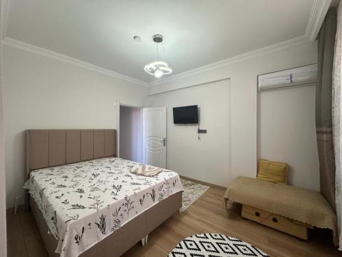 a small bedroom with a bed and a chair at Mürefte Suite in Tekirdağ