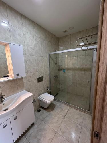 a bathroom with a shower and a toilet and a sink at Mira Beach Resort Bodrum - All inclusive in Bodrum City