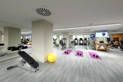 a gym with exercise equipment and a yellow ball in a room at Hard Rock Hotel Tenerife in Adeje