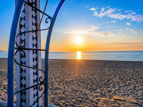 a surfboard sitting on the beach at sunset at Plage al amin eden in Fnidek