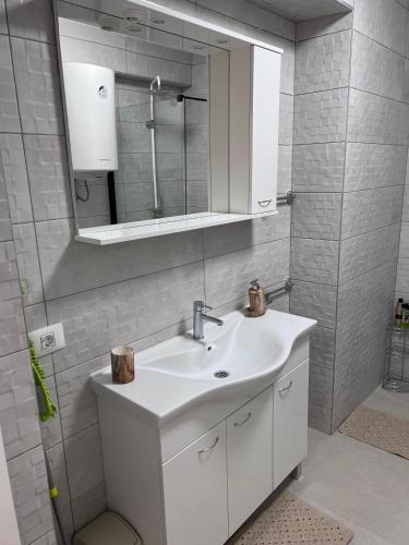 a bathroom with a white sink and a mirror at Apartman Quattro 2 in Međugorje