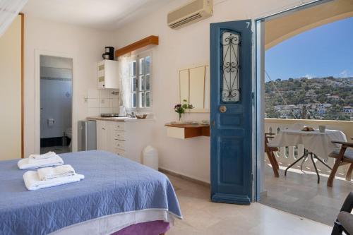 a room with a bed and a kitchen with a window at Yiorgo's Studios in Kalymnos