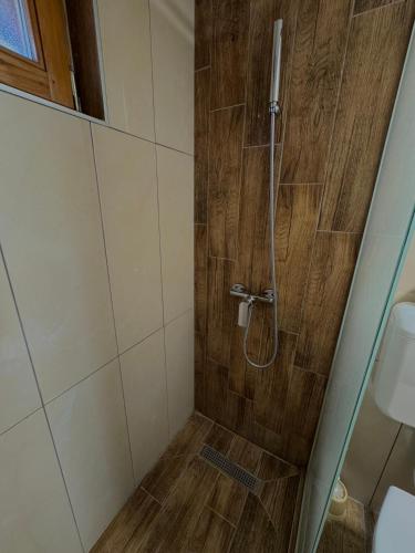 a bathroom with a shower with a wooden wall at Vlasic Odmor - Villa Kraljica in Vlasic