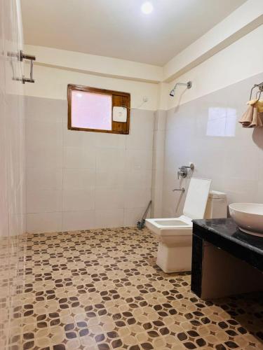 a bathroom with a toilet and a sink at Above & Beyond - Tirthan in Banjār