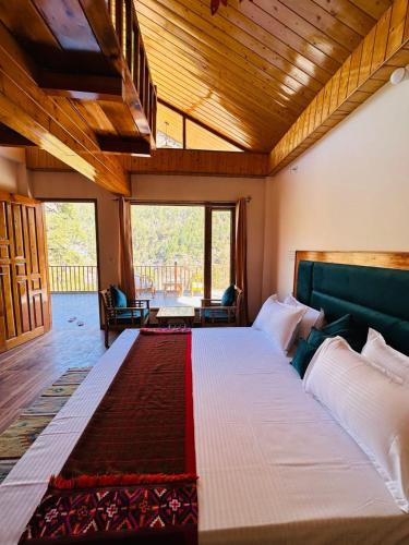 a bedroom with a large bed in a room at Above & Beyond - Tirthan in Banjār