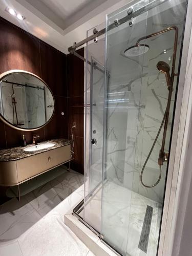 a bathroom with a glass shower and a sink at Macdonald Residence in Lagos