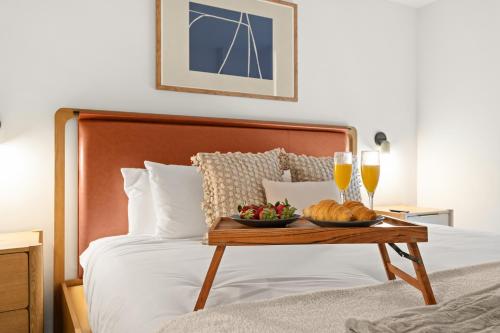 a bed with a tray of food and two glasses of wine at 1Bd Top Location Downtown Miami in Miami