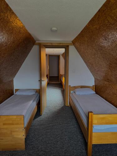 two beds in a room with a attic at Vlasic Odmor - Villa Kraljica in Vlasic