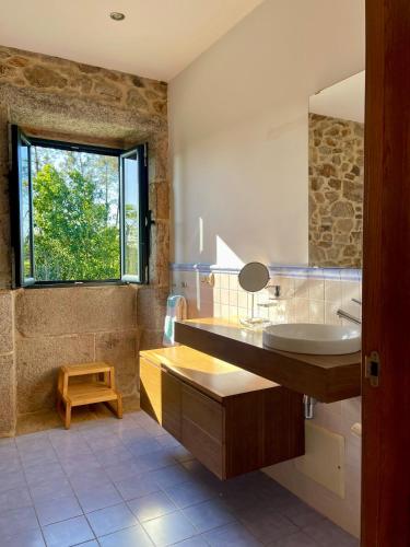 a bathroom with a sink and a mirror at Casa Rural A Redondiña in Lamas