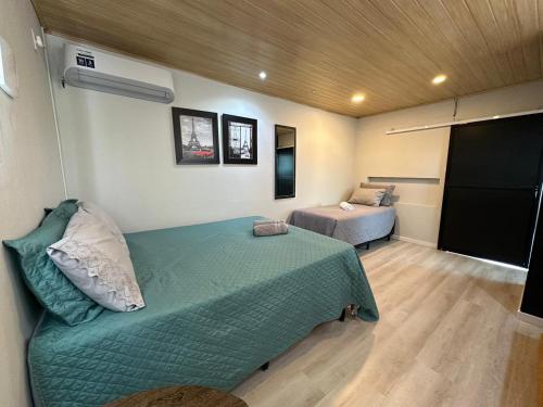 a bedroom with a bed and a couch in a room at Studio Aconchegante - com Garagem Privativa e Ar Condicionado REV391 in Joinville