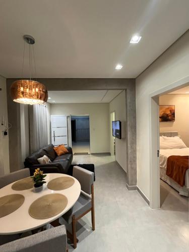 a living room with a table and a bed at Casa Nova, 2 quartos, 1 Ar-Cond, 1 Banheiro, Garagem 4,30m in Montes Claros
