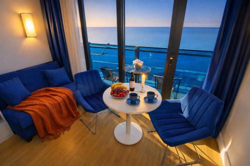 a room with a table and chairs and a view of the ocean at Panorama ORBI CITY LUXURY in Batumi