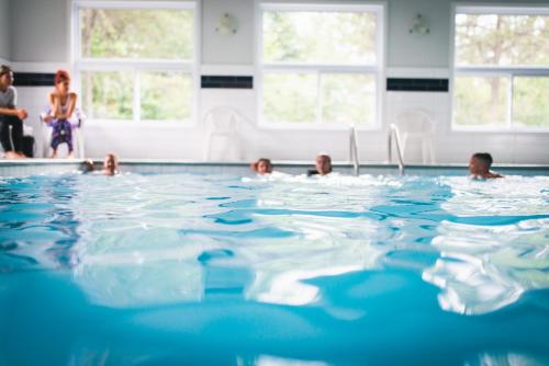 a group of people in the water in a swimming pool at Chalets Montmorency Mont-Sainte-Anne in Saint-Férréol-les-Neiges