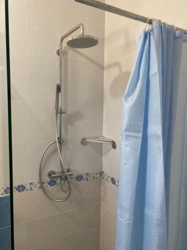 a shower with a blue shower curtain in a bathroom at Villa dhiefa avec piscine in Temlale