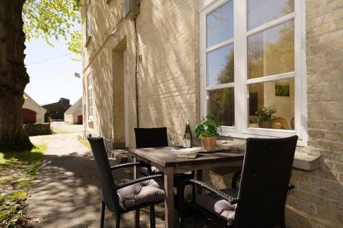 an outdoor table with chairs and a window at Gut Staberhof Staberwind in Staberdorf
