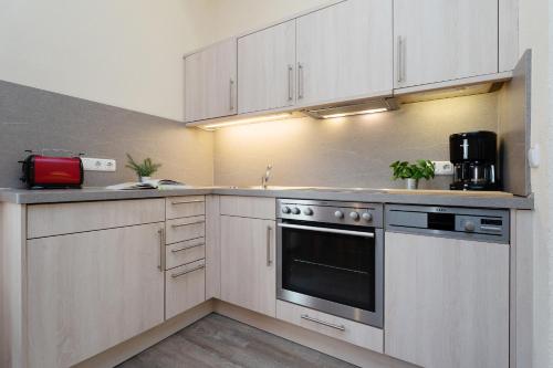 a kitchen with white cabinets and a stove top oven at Gut Staberhof Staberwind in Staberdorf