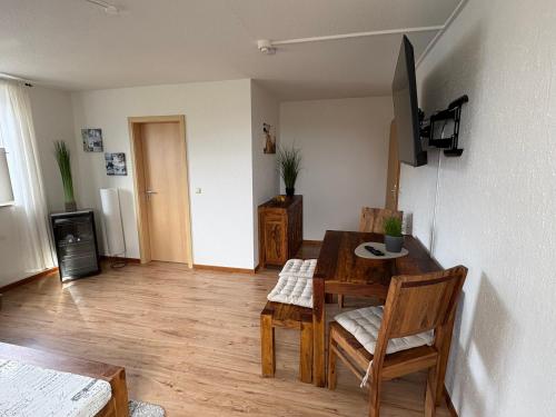 a living room with a table and chairs and a television at Ostseekoje Koje 4 in Süssau