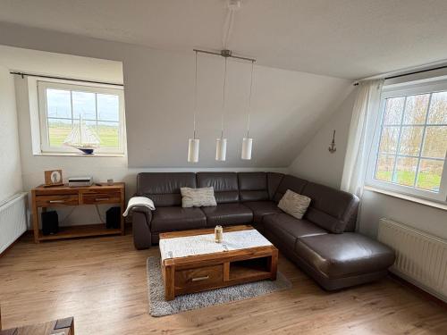a living room with a leather couch and a table at Ostseekoje Koje 4 in Süssau