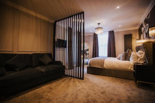 a bedroom with a bed and a couch and a mirror at The Mill Sharnbrook - Bedford in Sharnbrook