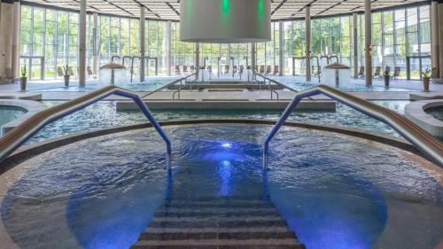 a large pool of water in a building with stairs at LaBONI Apartman in Miskolctapolca