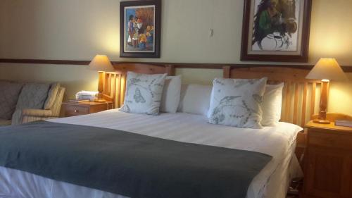 a bedroom with a large bed with white sheets and pillows at Chez Esme Guest House in Roodepoort