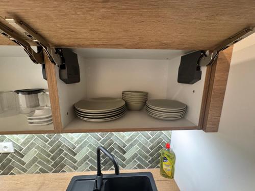 a kitchen cabinet with plates and dishes in it at Ferienhaus Schmiedweg 10 in Altmünster