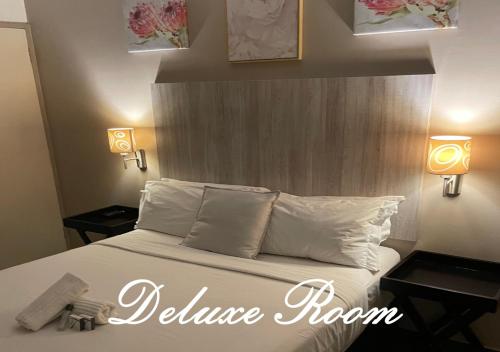 a bedroom with a bed with white pillows and two lights at Travel Lodge in Middelburg