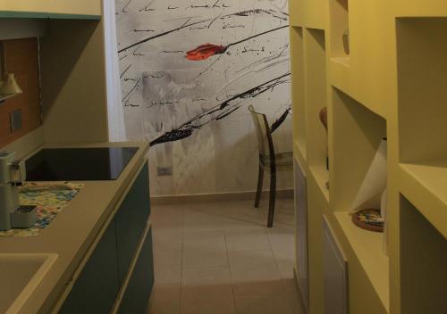 a kitchen with a painting on the wall and a chair at L'Abbraccio in Tivoli