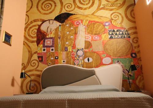 a bedroom with a wall with a painting on it at L'Abbraccio in Tivoli