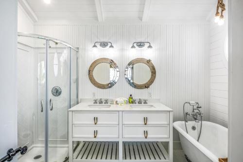 a white bathroom with a tub and a sink and mirror at CJ286FLR LUX-Parrotfish Point in Cudjoe Key