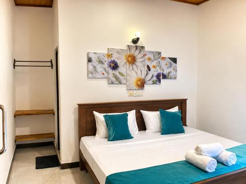 a bedroom with a bed with blue and white pillows at Ceylon Beach haven Uppuveli in Trincomalee