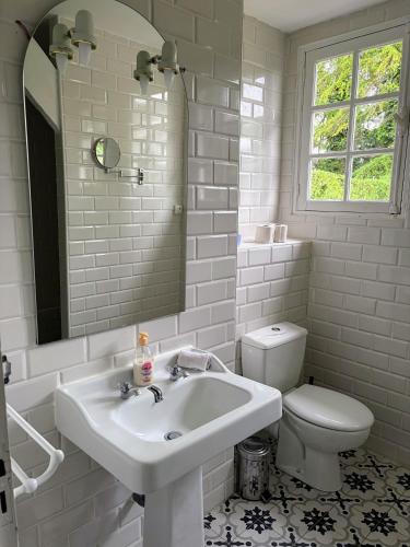 a white bathroom with a sink and a toilet at Maison de famille - Proche Centre Ville et Plage in Cabourg