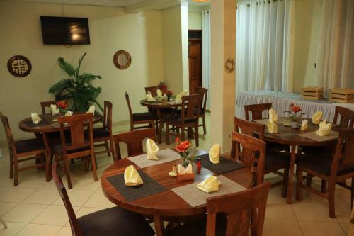 a dining room with wooden tables and chairs at Hotel Casabella in Entebbe