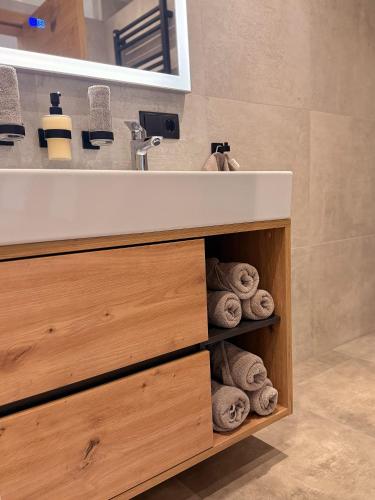 a bathroom with a sink and a pile of towels at Apartment Bergliebe in Sellrain