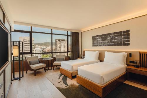 a hotel room with two beds and a window at Nobu Hotel Barcelona in Barcelona