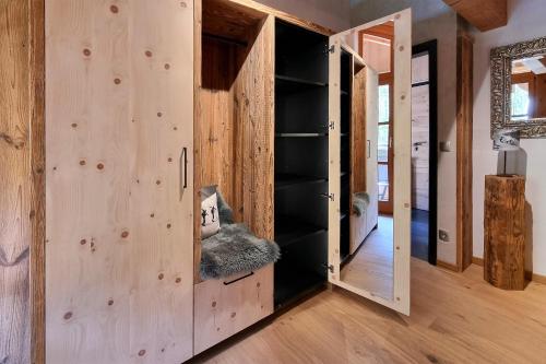 a room with wooden walls and a door with shelves at Ferienhaus Alpenblick in Mittenwald