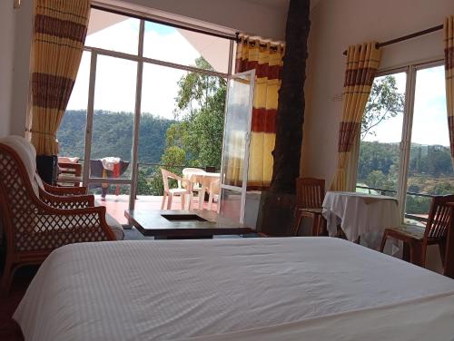a bedroom with a bed and a large window at woods hut in Nuwara Eliya