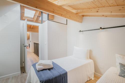 a bedroom with a white bed and a wooden ceiling at Casa Da Rita in Matapozuelos