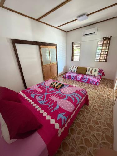 a room with two beds and a couch in it at Ohotu Lodge in Rangiroa