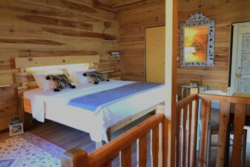 a bedroom with a bed in a log cabin at le Chalet in Saint-Loup-sur-Thouet