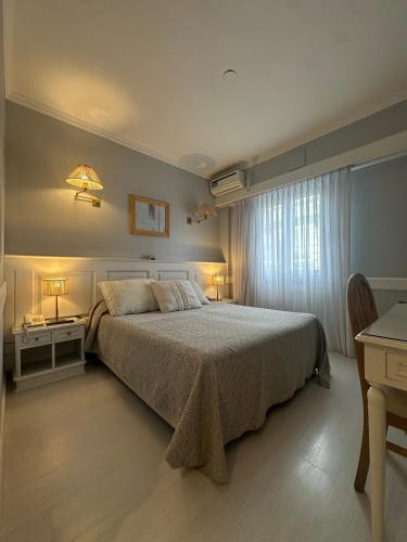 a bedroom with a bed and a desk and a window at Hotel Valles in Mar del Plata
