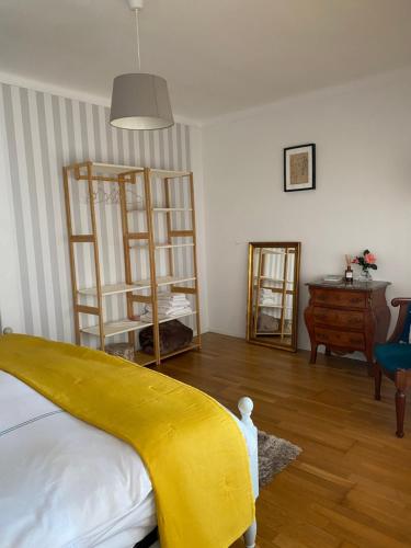a bedroom with a bed with a yellow blanket on it at House in the Town Centre in Caminha